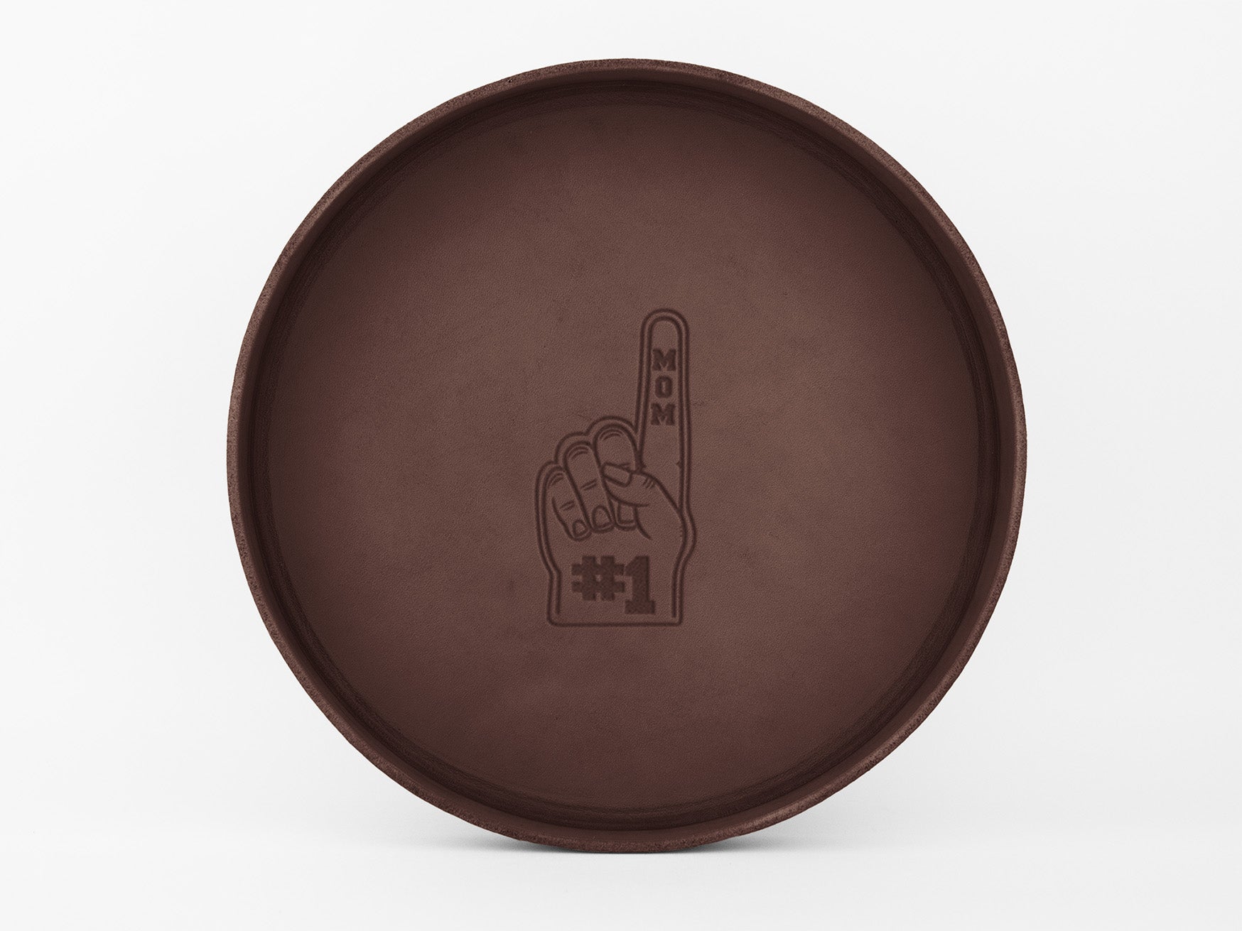 A round brown tray with an illustration of a foam finger in the center. The finger says MOM vertically and the palm displays #1. The background is plain white.