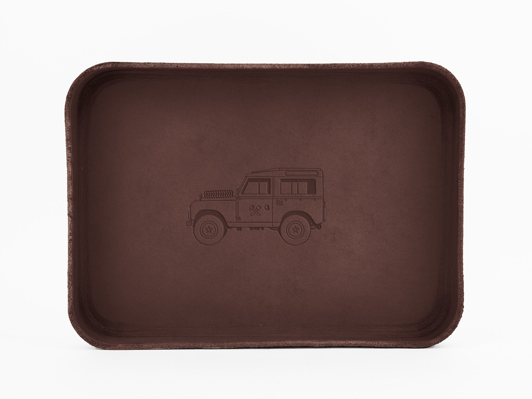 A rectangular, brown tray with rounded edges, featuring an embossed outline of a classic off-road vehicle in the center on a plain white background.