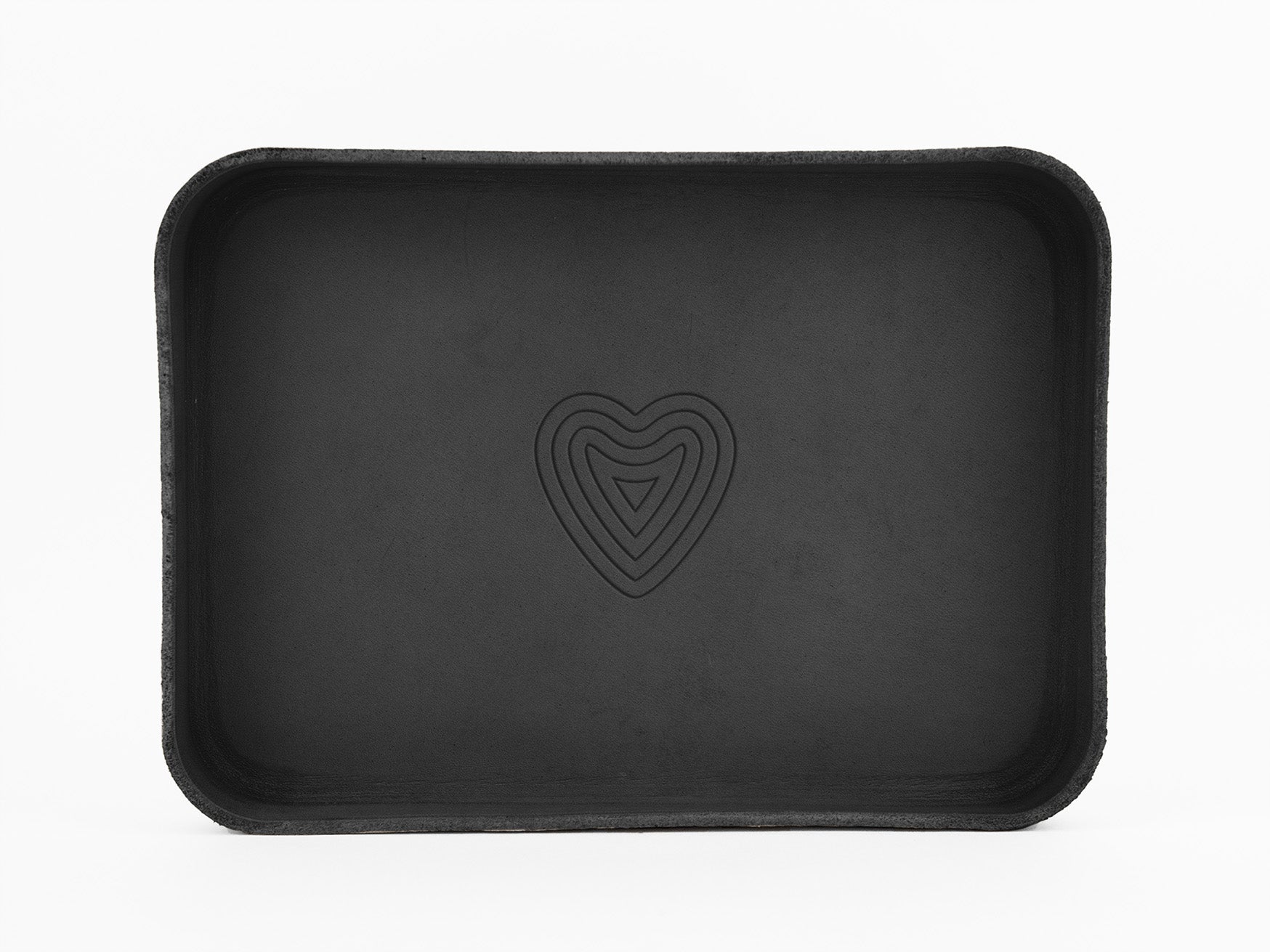A rectangular black tray with rounded corners featuring a simple heart-shaped design in the center, set against a white background.