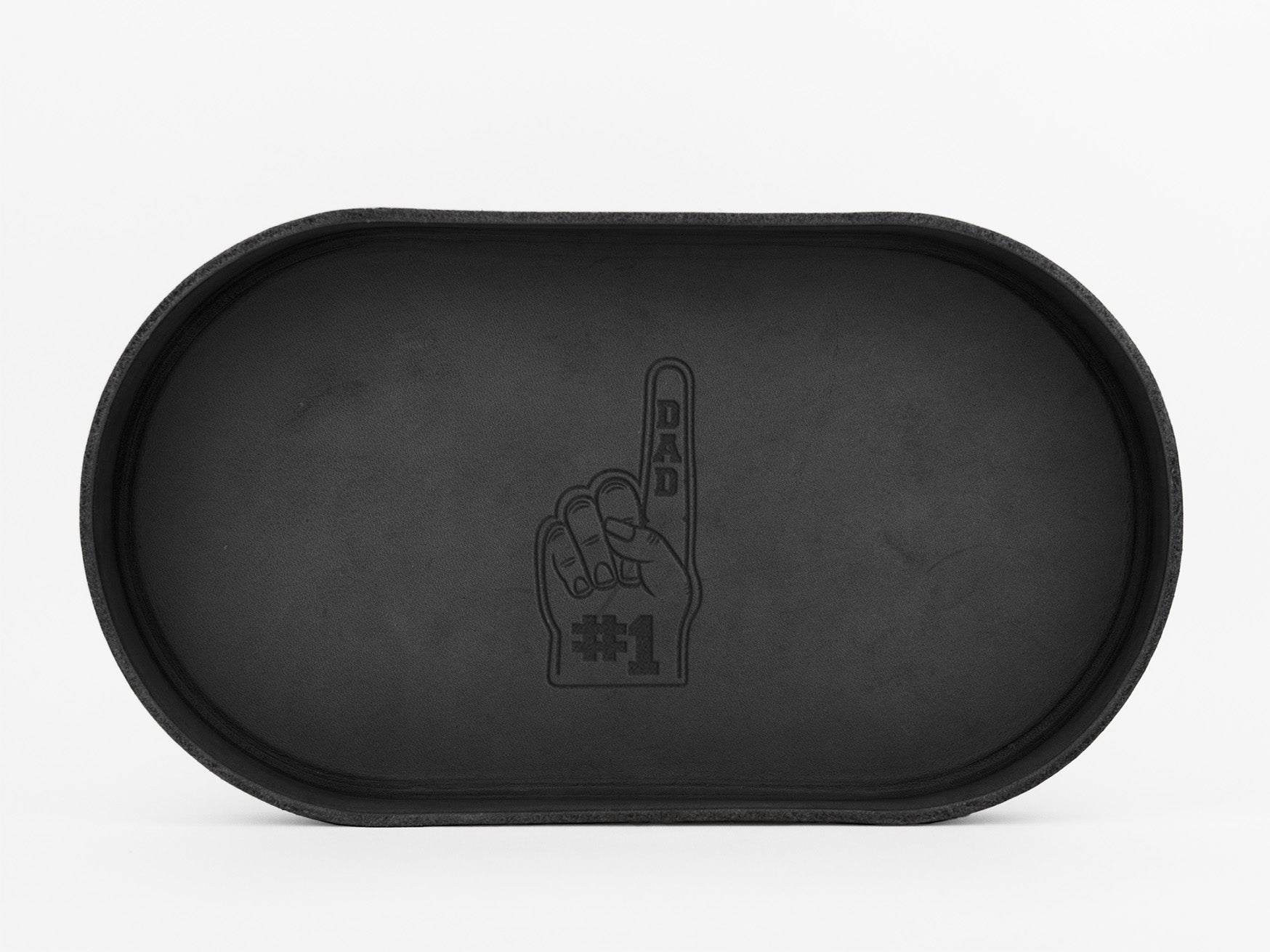 A black oval tray with an embossed foam finger graphic in the center, showing a raised index finger with the words DAD on the finger and #1 below it.