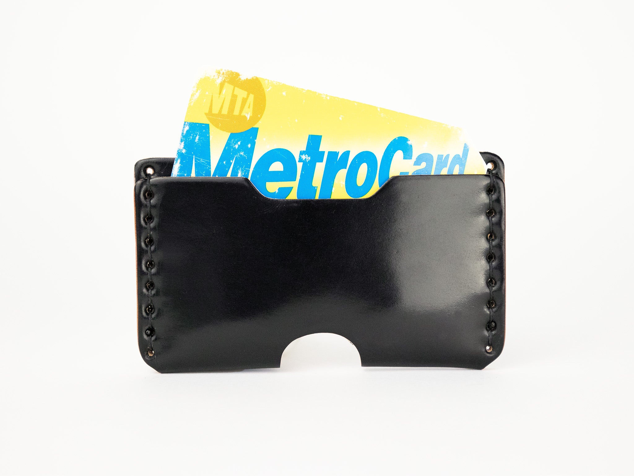 A black leather card holder with a yellow and blue MTA MetroCard partially visible inside.