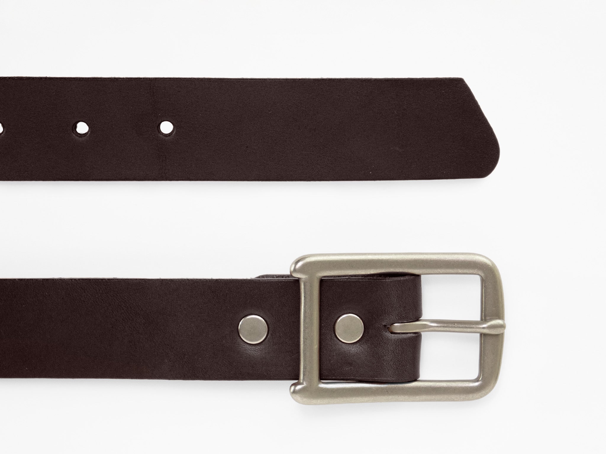 A dark brown leather belt with a silver rectangular buckle is shown laid flat on a white background. The belt has several holes and metallic rivet details near the buckle.