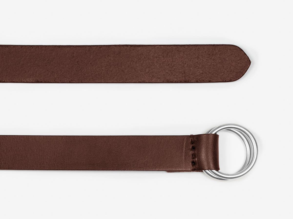 A brown leather belt with a pointed tip and a silver double ring buckle, displayed on a white background.