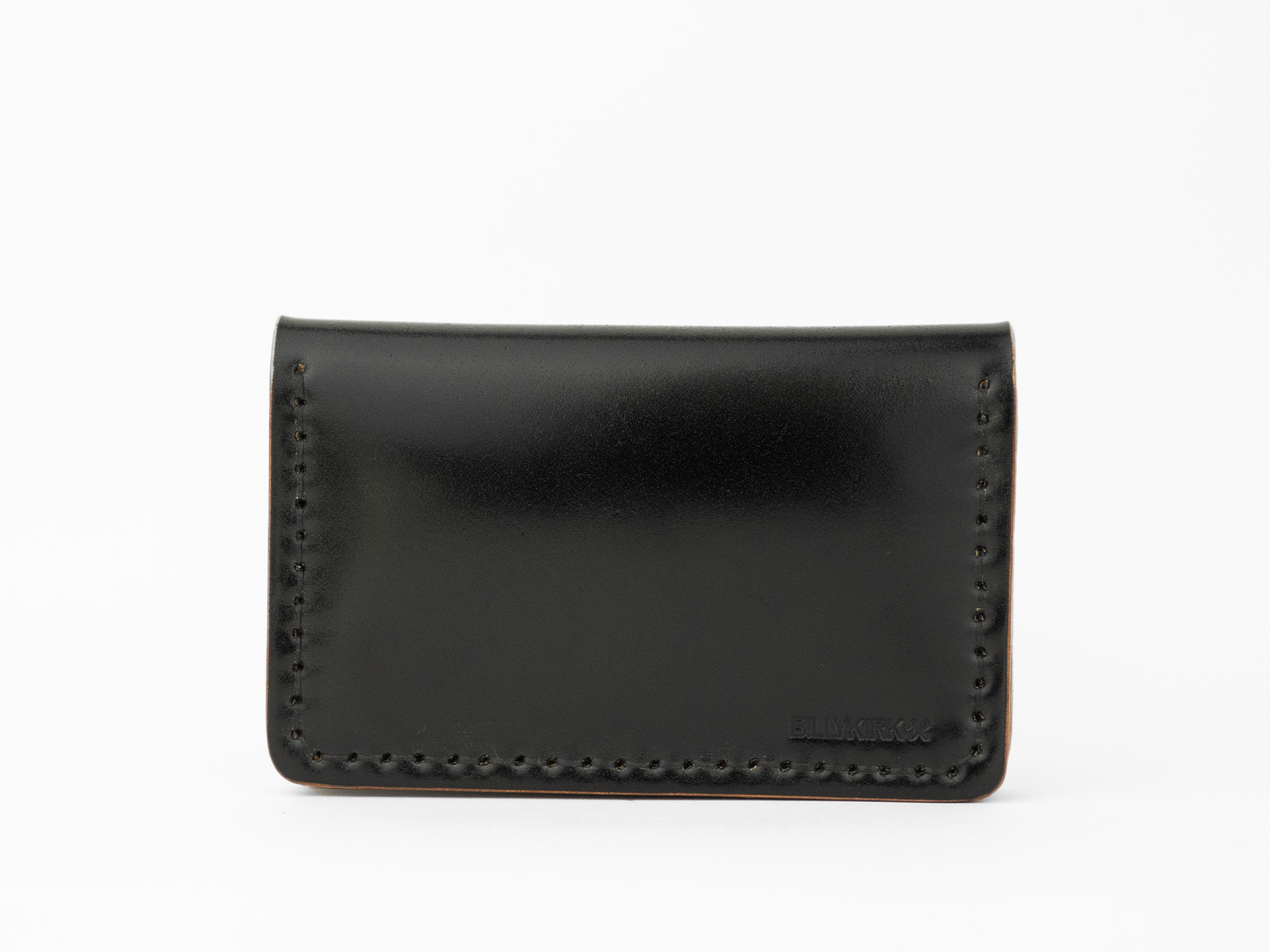A minimalist, black cordovan leather cardholder wallet with visible stitching around the edges and a subtle embossed BILLYKIRK logo in the lower right corner, set against a white background.