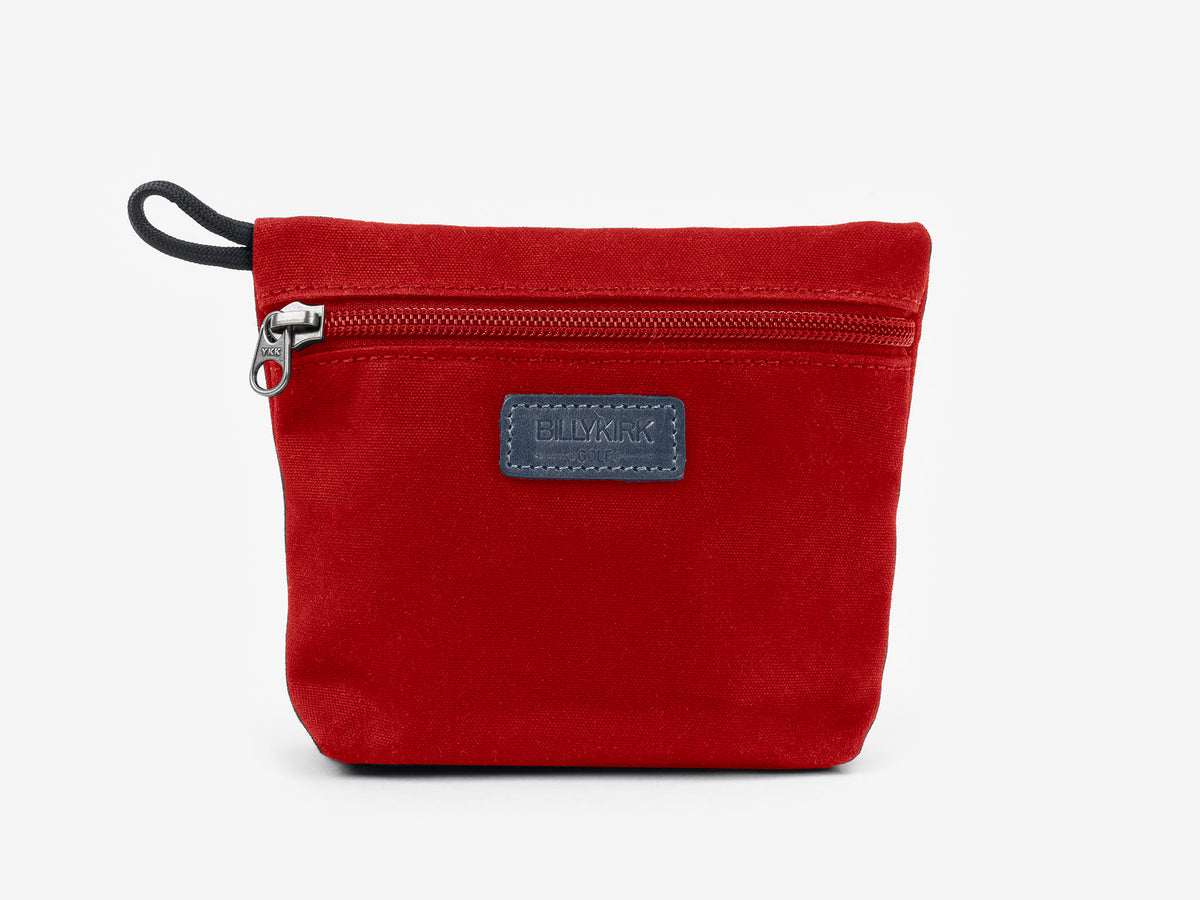 A small, rectangular red fabric pouch with a black zipper, a black loop on the left side, and a black rectangular patch labeled BIMKIK on the front. The pouch is set against a plain white background.