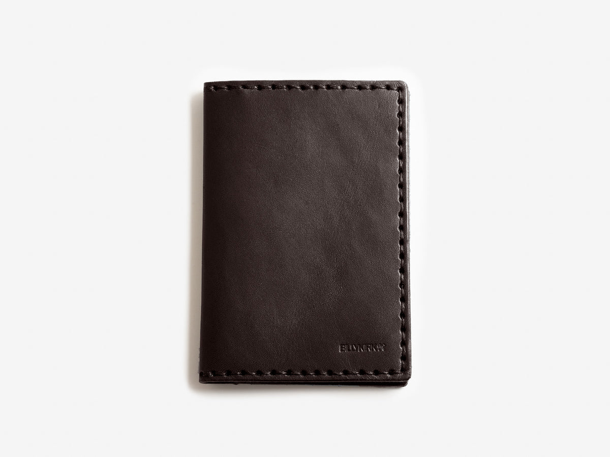 A closed, dark brown leather wallet with visible stitching along the edges, placed on a plain white background. The word BELLROY is embossed in small letters in the bottom right corner.