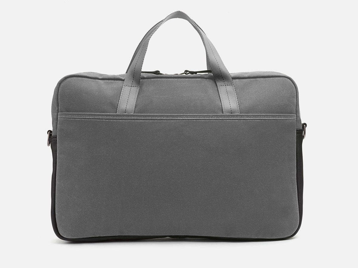 A plain gray fabric laptop bag with two short handles, a front zipper pocket, and black trim on the sides, photographed against a white background.