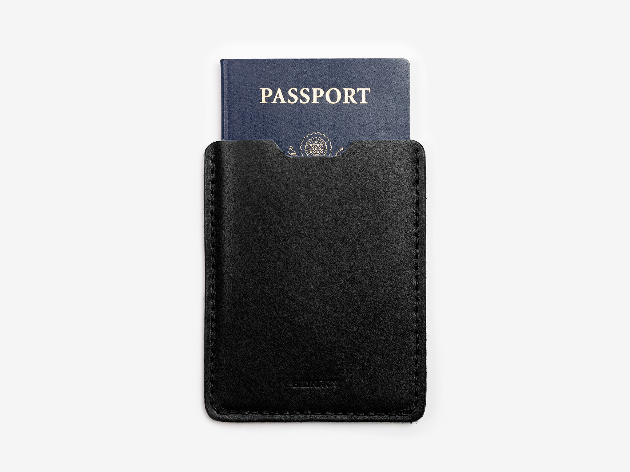 A navy blue passport partially tucked into a sleek black leather holder, shown against a plain white background.