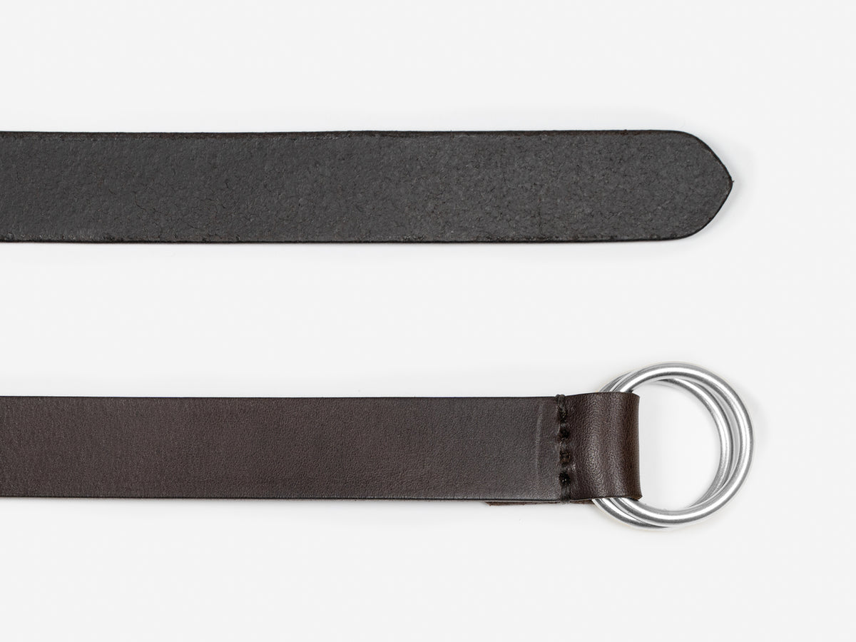 A dark brown leather belt with a silver double D-ring buckle, shown laid flat on a white background.