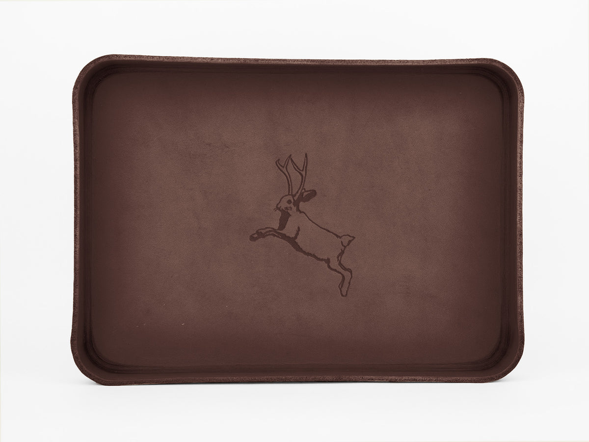 A rectangular brown tray with raised edges features an illustration of a leaping jackalope, a mythical animal with antlers, in the center.