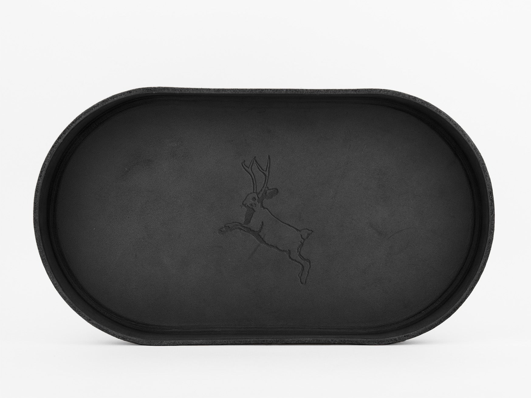 A black oval tray with a subtle engraved outline of a leaping hare or jackrabbit in the center, set against a plain white background.