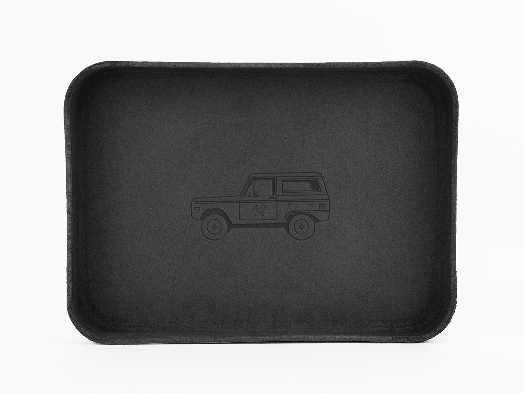 A black rectangular tray features a subtle outline drawing of an SUV or off-road vehicle at its center, set against a plain white background.