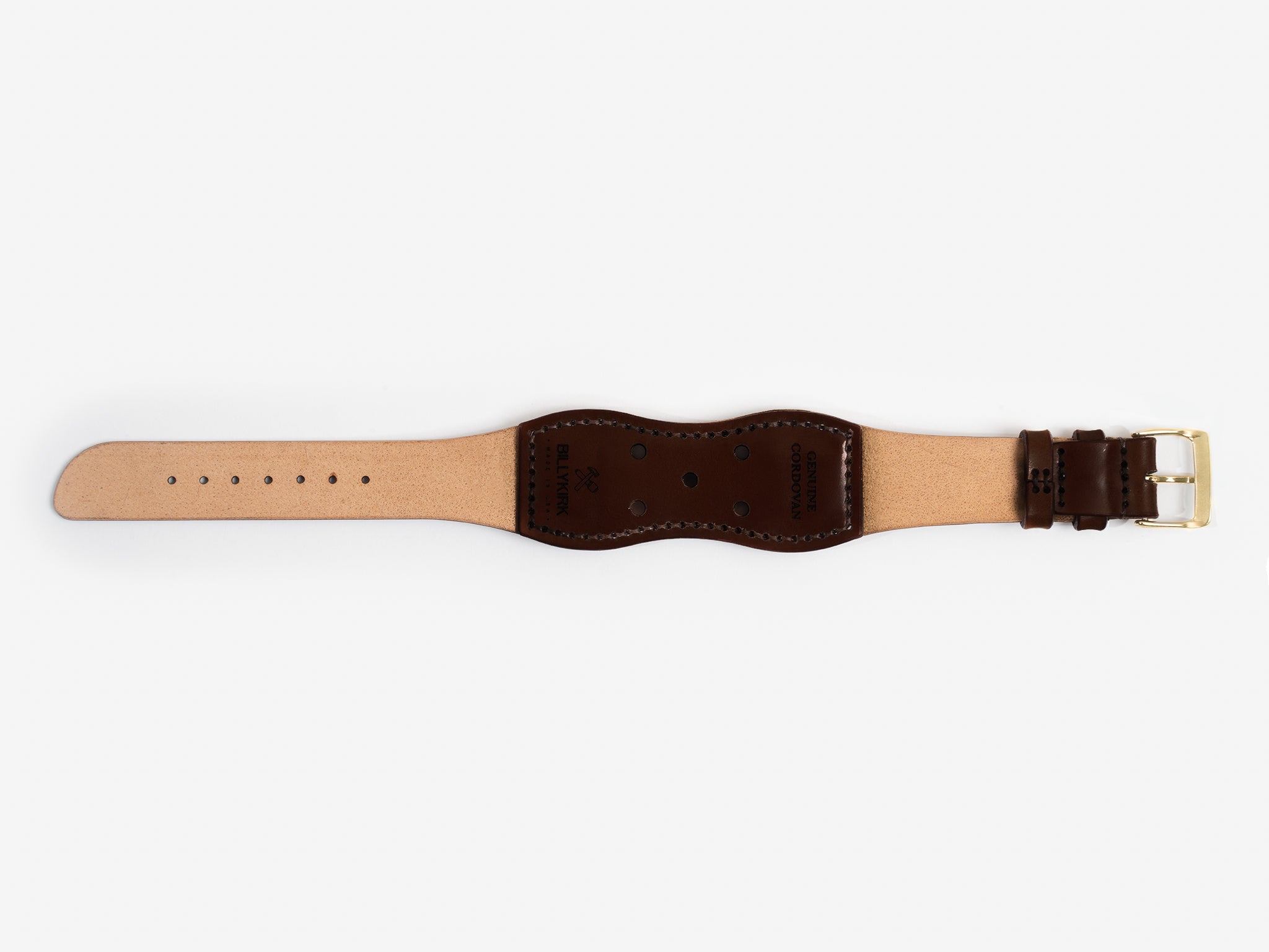 The back of a dark brown cordovan leather watch strap with a brass buckle lies flat on a white background; it has brown thread stitched edges and an hourglass shape.