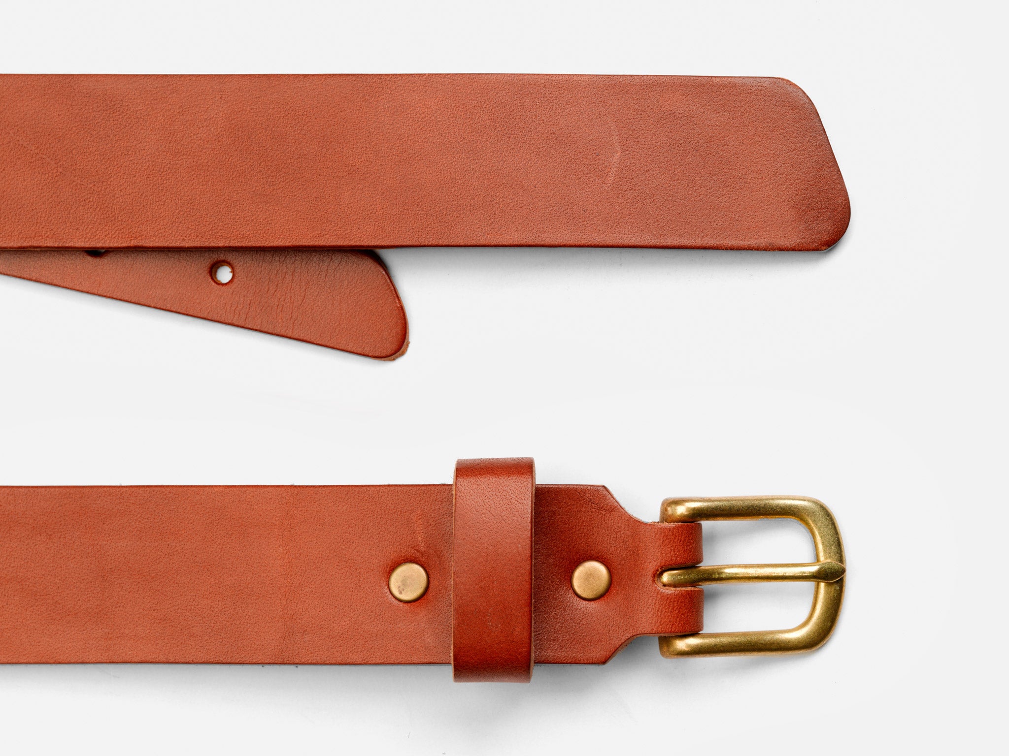 A close-up of a brown leather belt with a brass buckle, displayed on a white background. The belt is shown unbuckled, with one end overlapping the other.