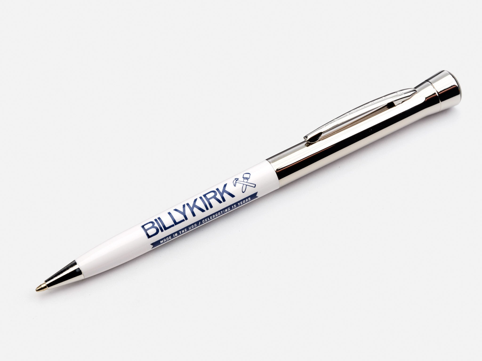A white and silver ballpoint pen with the brand name BILLYKIRK and two crossed hammers printed on the barrel, displayed on a plain white background.