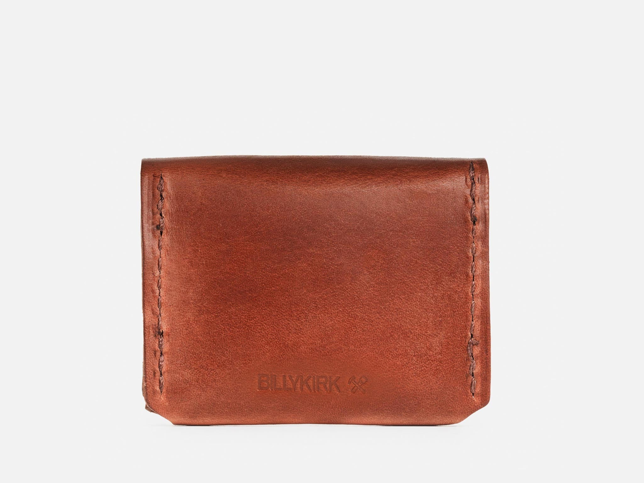 The back of a tan coin pouch with hand-stitched edges with a Billykirk logo embossed at the bottom