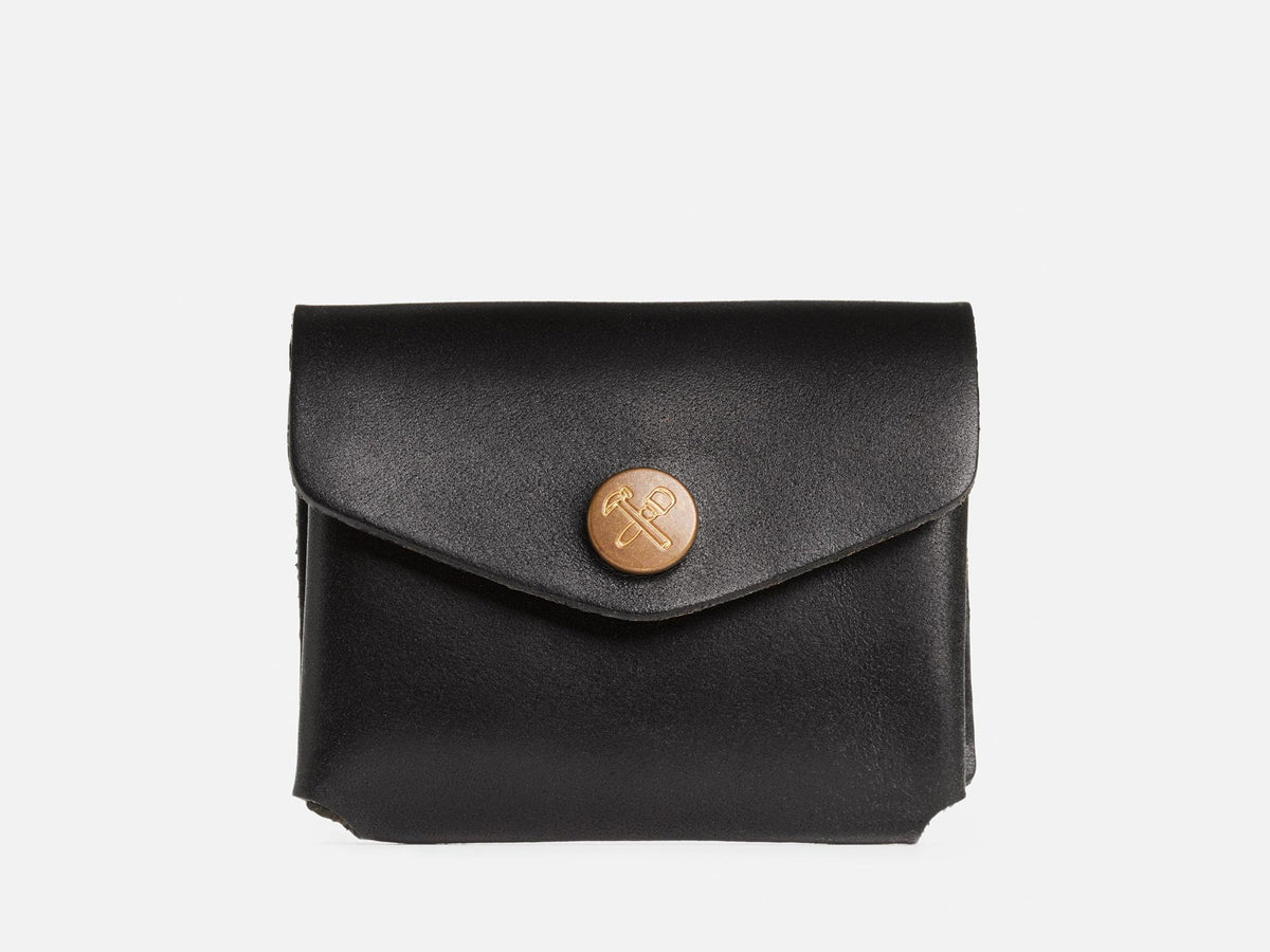 A closed black coin pouch with a brass snap featuring a hammer and maul logo