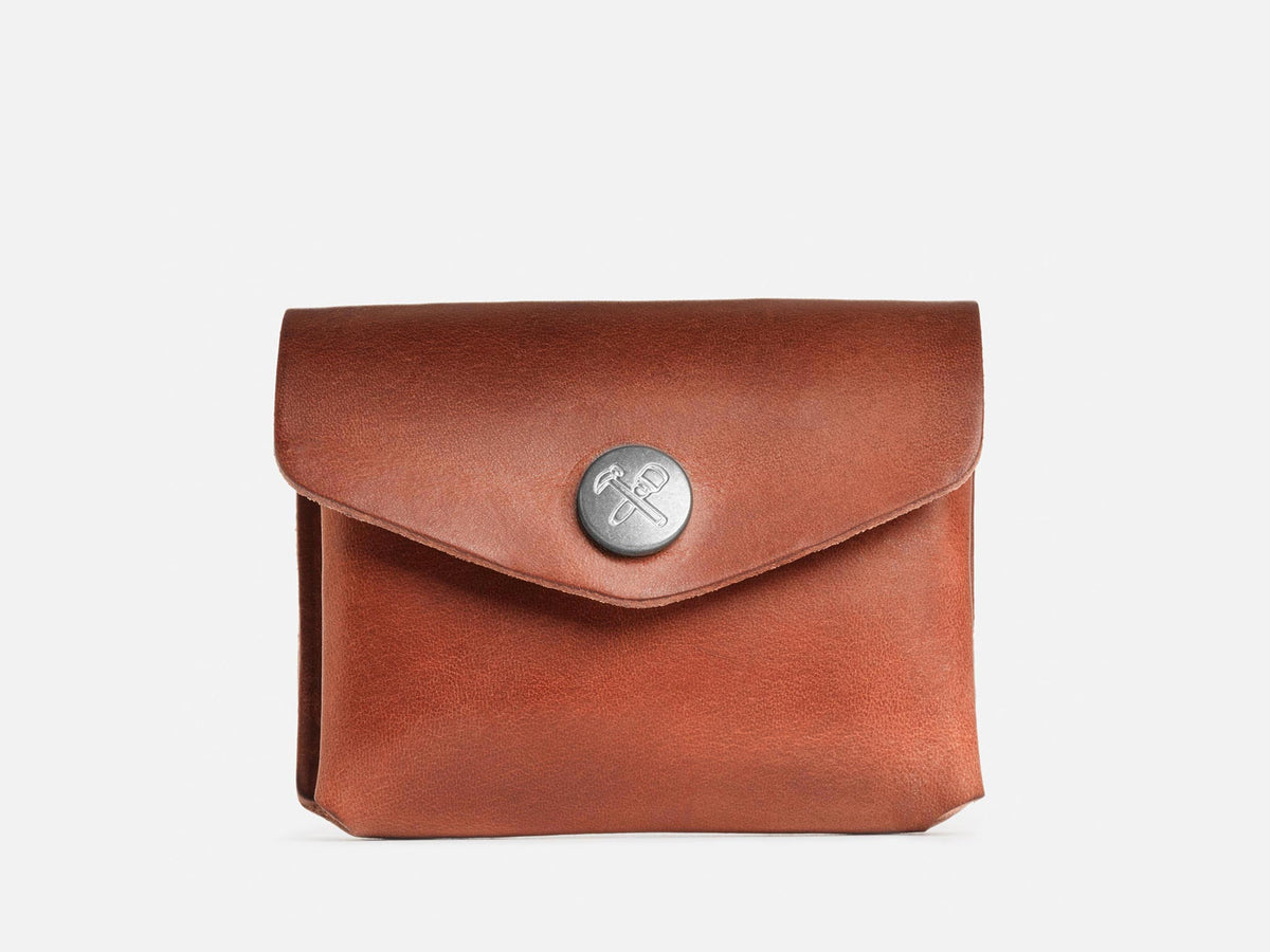 A closed black coin pouch with a nickel snap featuring a hammer and maul logo