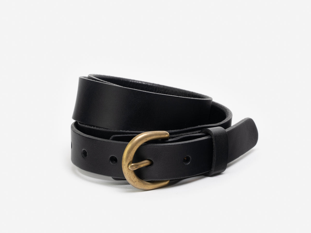 A coiled black leather belt with a brass rounded buckle is displayed against a plain white background.