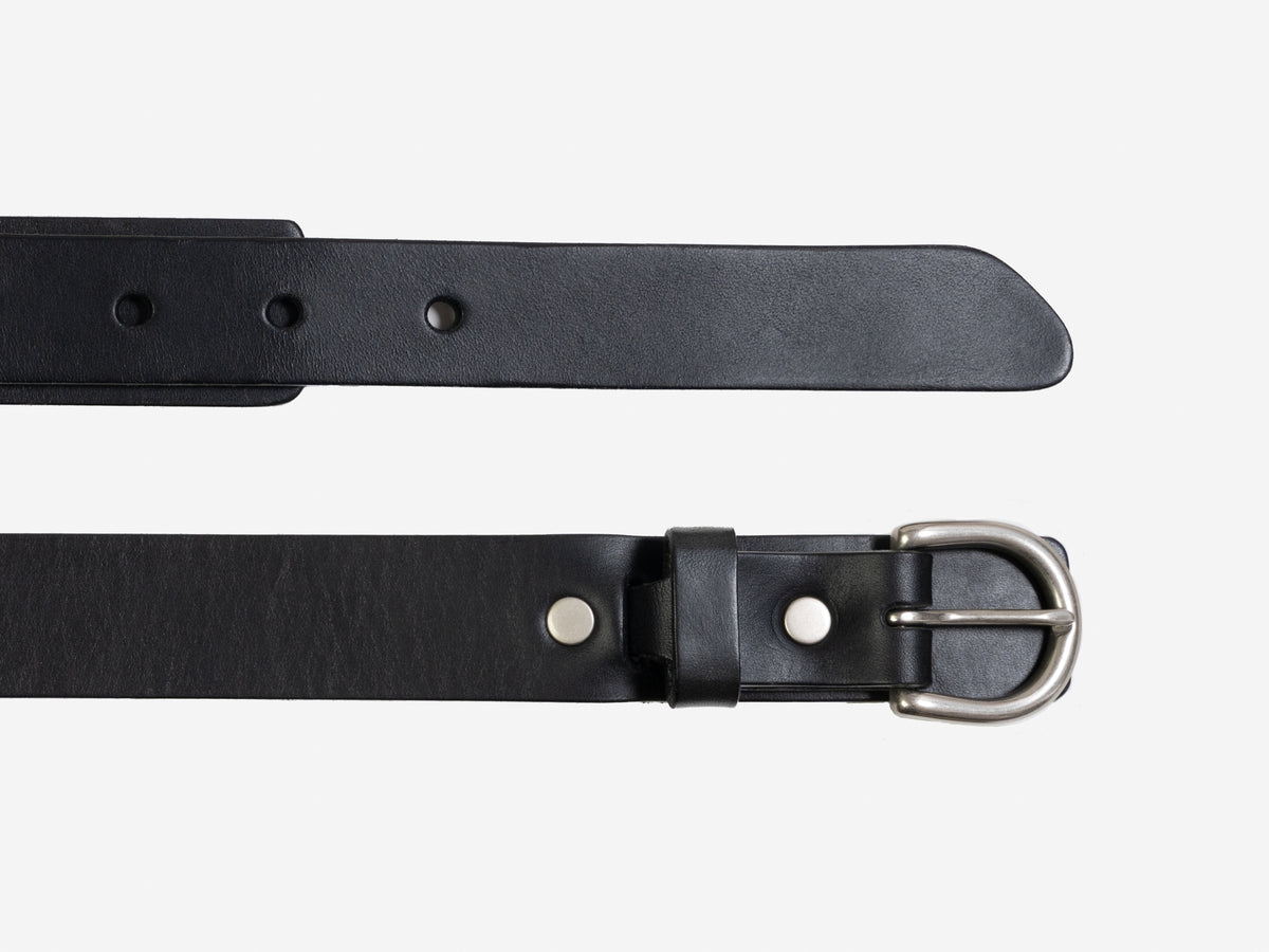 A black leather belt with a silver buckle is shown laid flat against a white background. The belt has multiple holes for adjustment and metal rivets near the buckle.