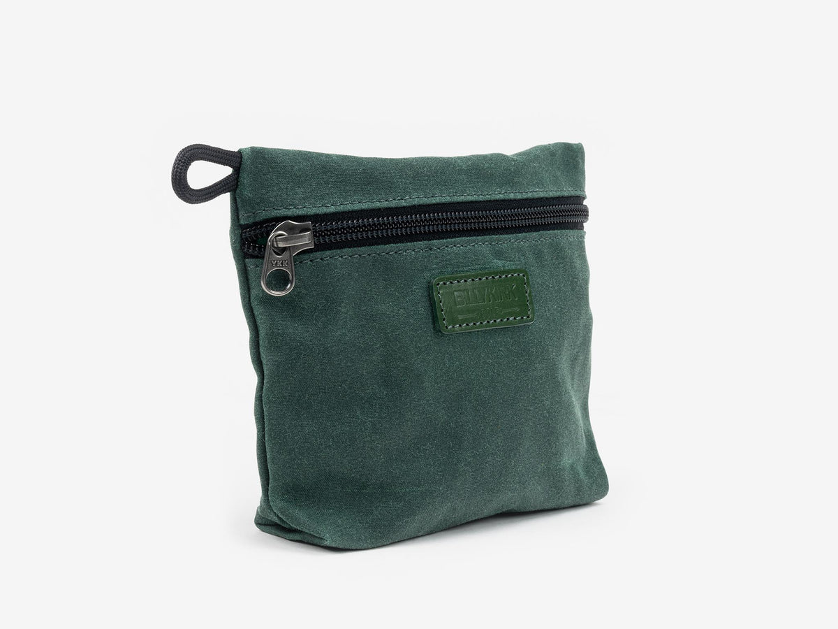A small, square, dark green fabric pouch with a black zipper and a short black loop on one side, displayed against a plain white background.