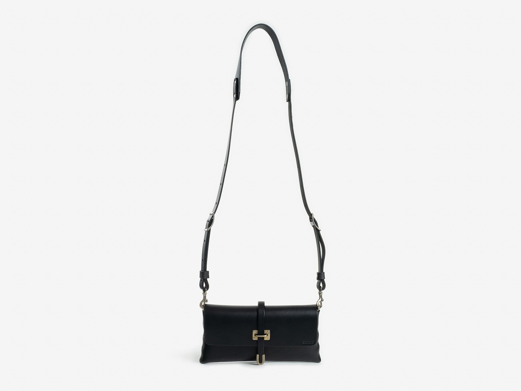 A black leather crossbody bag with a gold-tone clasp and an adjustable shoulder strap, displayed against a plain white background.