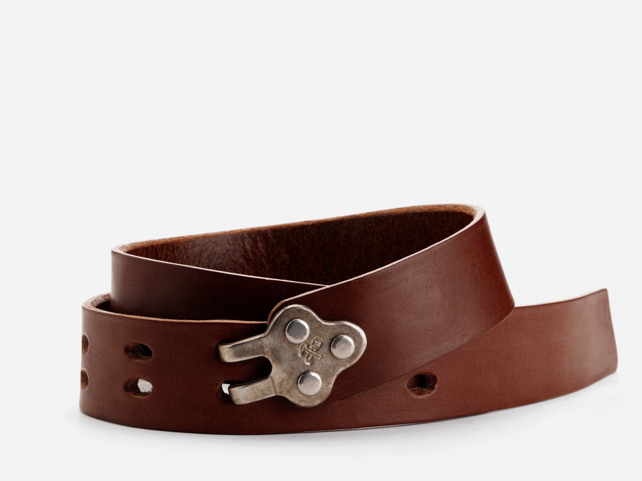 A brown leather belt with a unique, industrial-style metal buckle, coiled loosely on a white background.