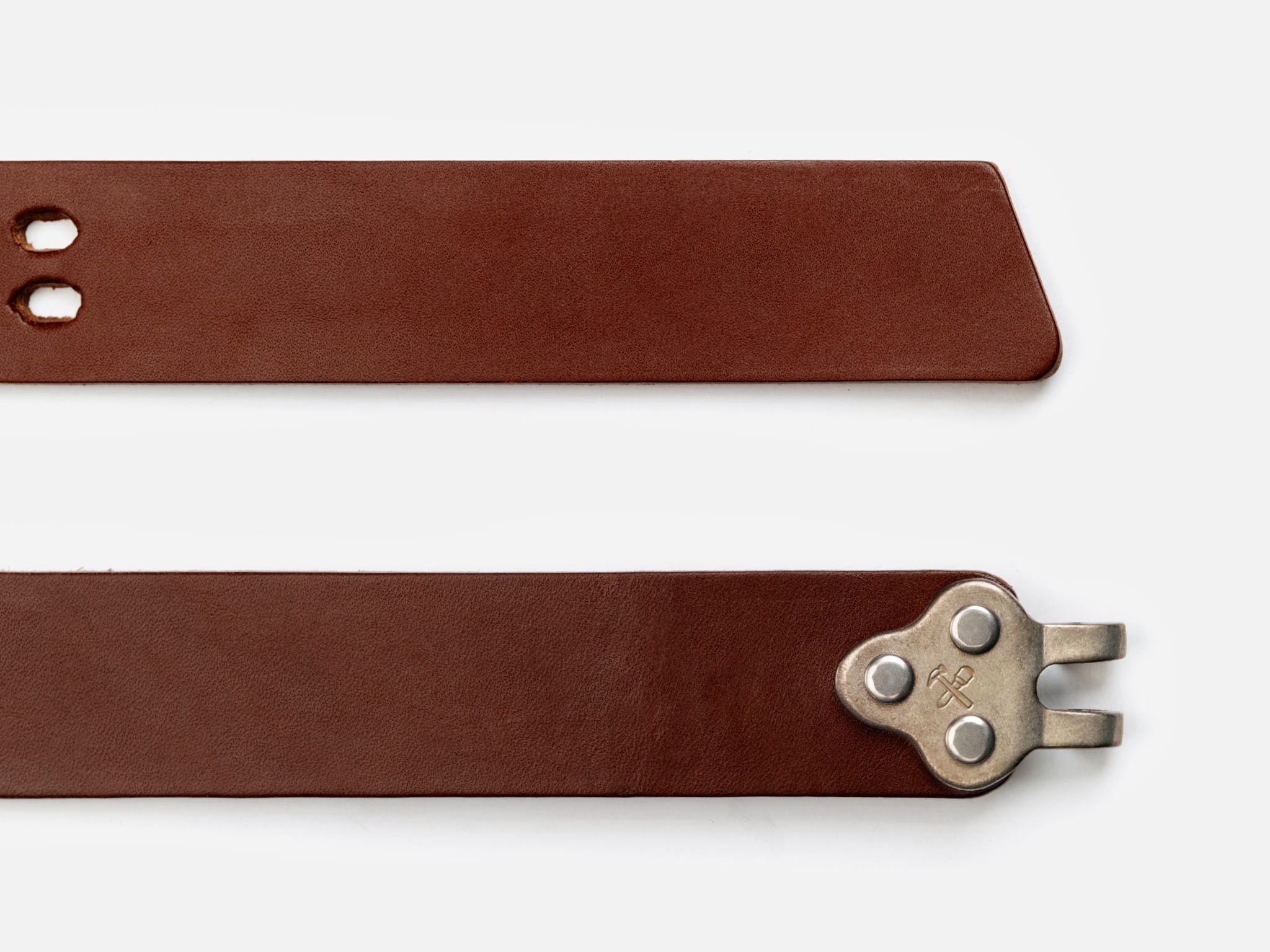 Two brown leather belt straps are shown. One end has a pointed tip with two holes, and the other end features a unique silver metal buckle mechanism with three rivets. The background is white.